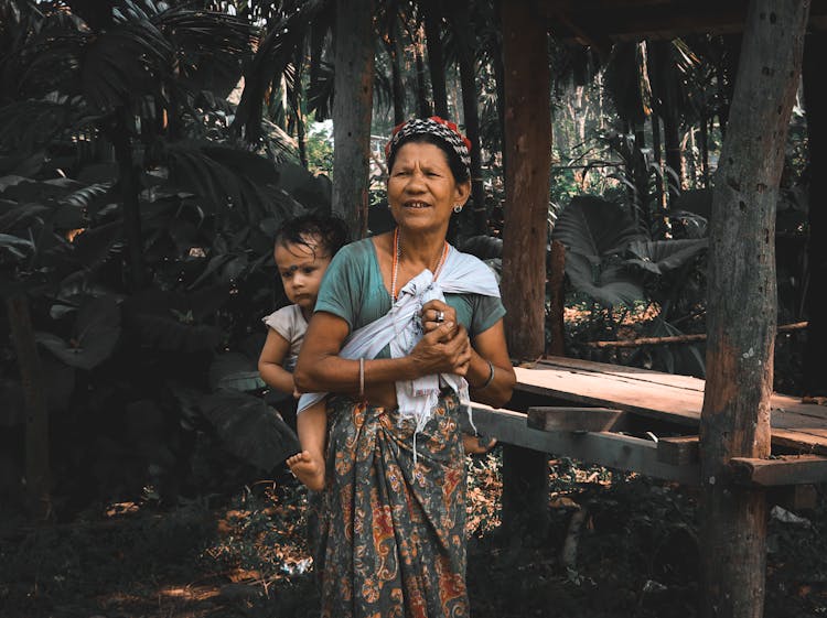 Woman In Blue T-shirt Carrying Baby