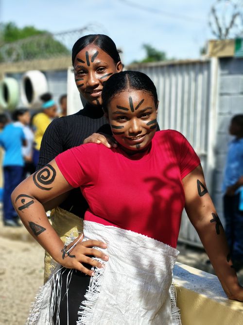 Free Two adults with artistic face paint pose at an outdoor cultural festival. Stock Photo