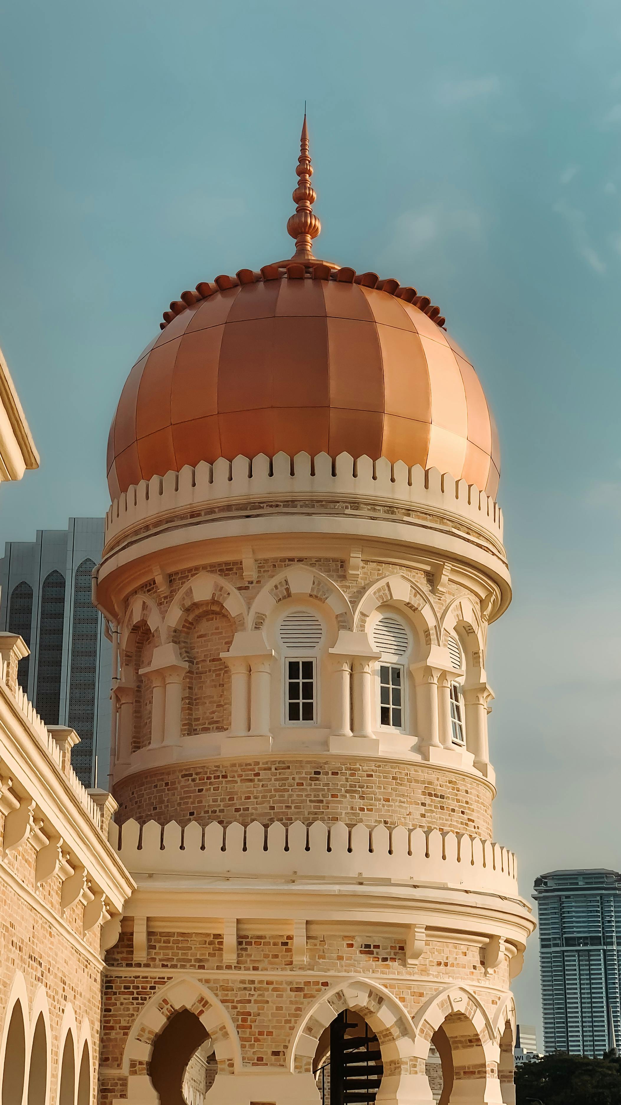 Architectural detail of the Sultan Abdul Samad Building's iconic dome under a clear sky in Kuala Lumpur.