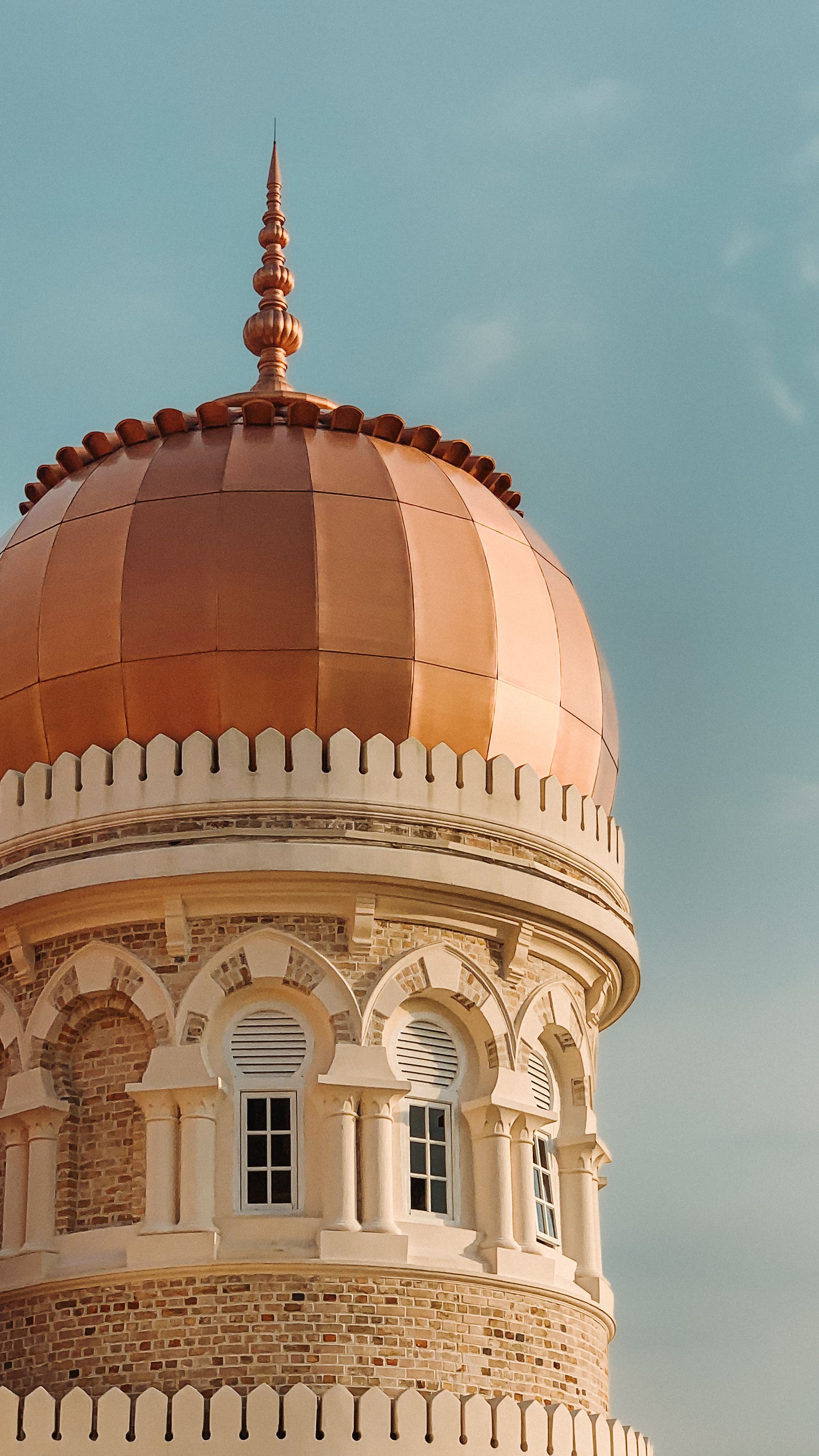 A striking view of a copper dome against a clear sky in Kuala Lumpur, Malaysia.