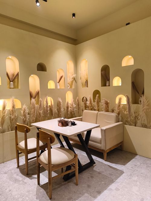Free Warm cafe interior with stylish table and chairs, decorative shelves and muted lighting. Stock Photo