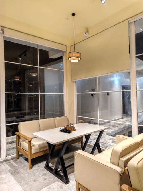 Free A cozy and stylish corner of a café featuring a sleek table and comfortable seating. Stock Photo