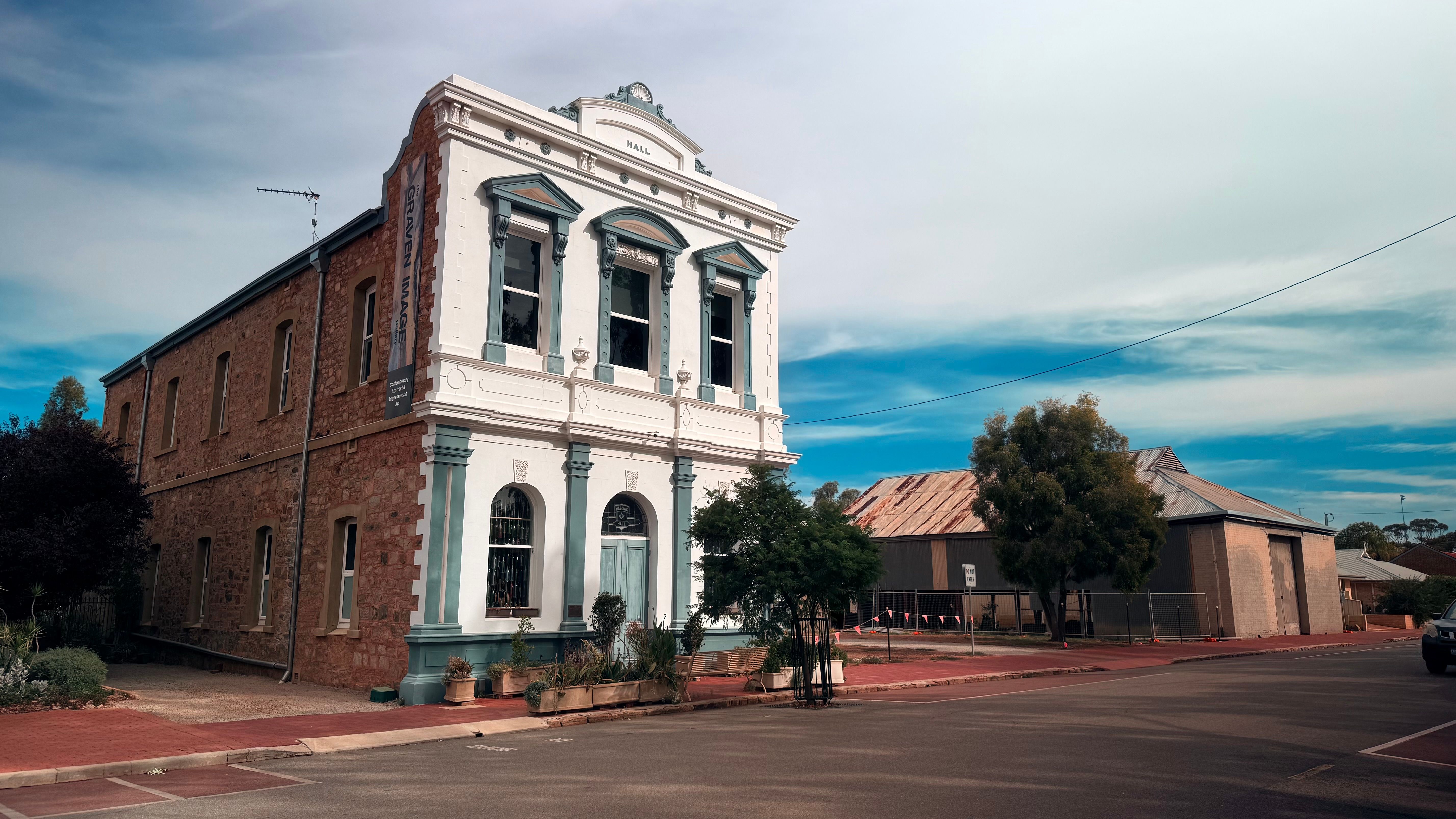 Old town hall building with blue sky background in a quiet village setting.