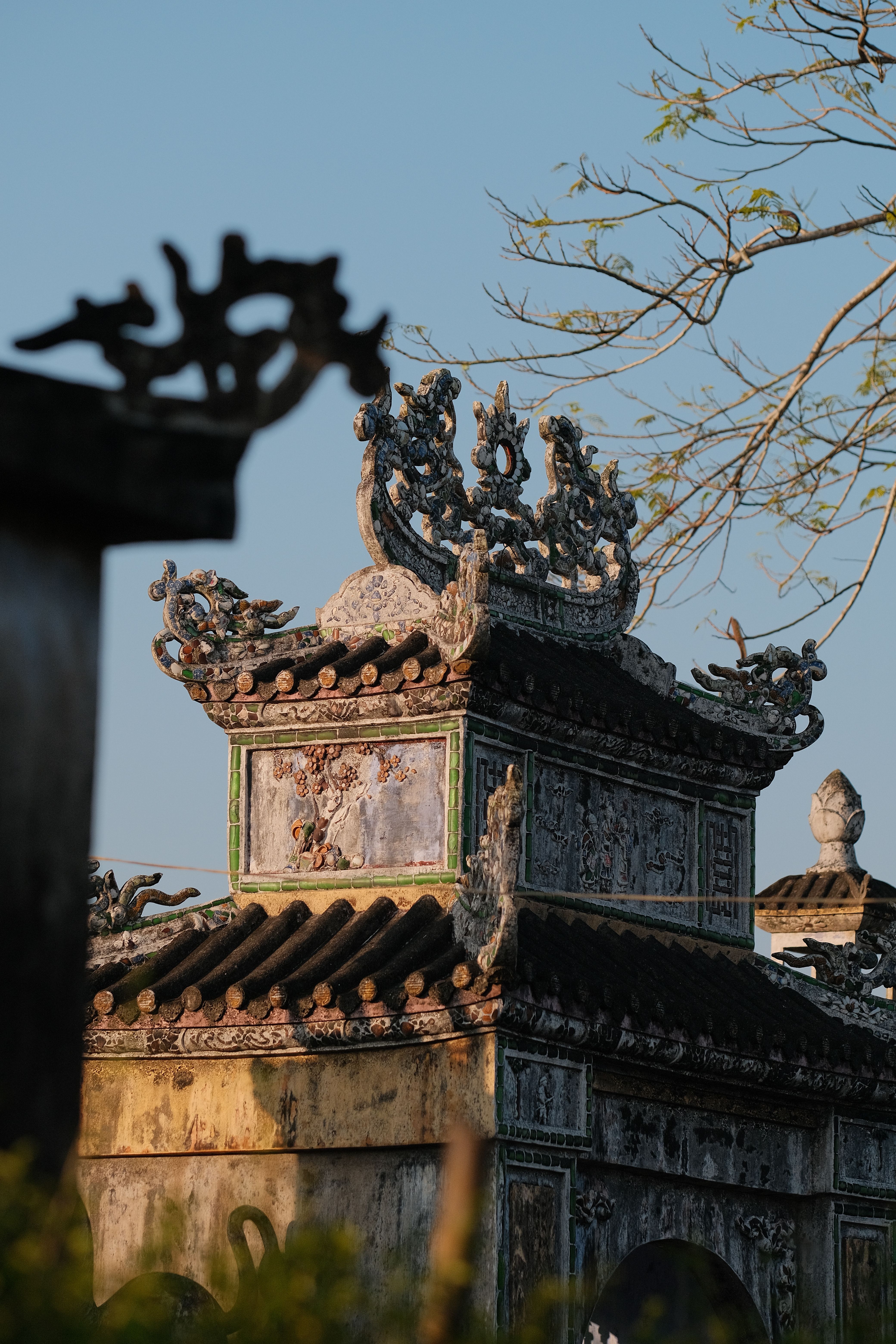 An intricate structure under a vibrant sunset, showcasing detailed Asian architectural design.