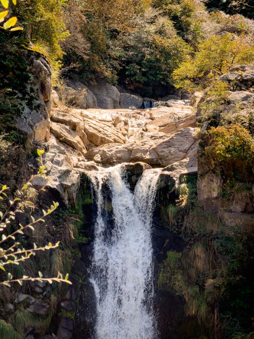 Free Beautiful waterfall cascading over rocky cliffs surrounded by lush greenery in La Cumbrecita, Córdoba, Argentina. Stock Photo