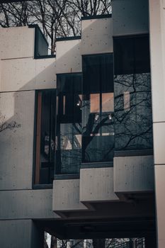 Stylish modern building with glass panels and concrete design, reflecting urban architecture.