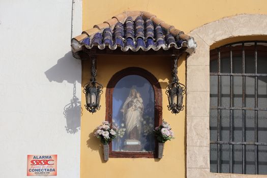 A detailed view of a religious shrine with a Virgin Mary statue in El Puerto de Santa María, Spain.