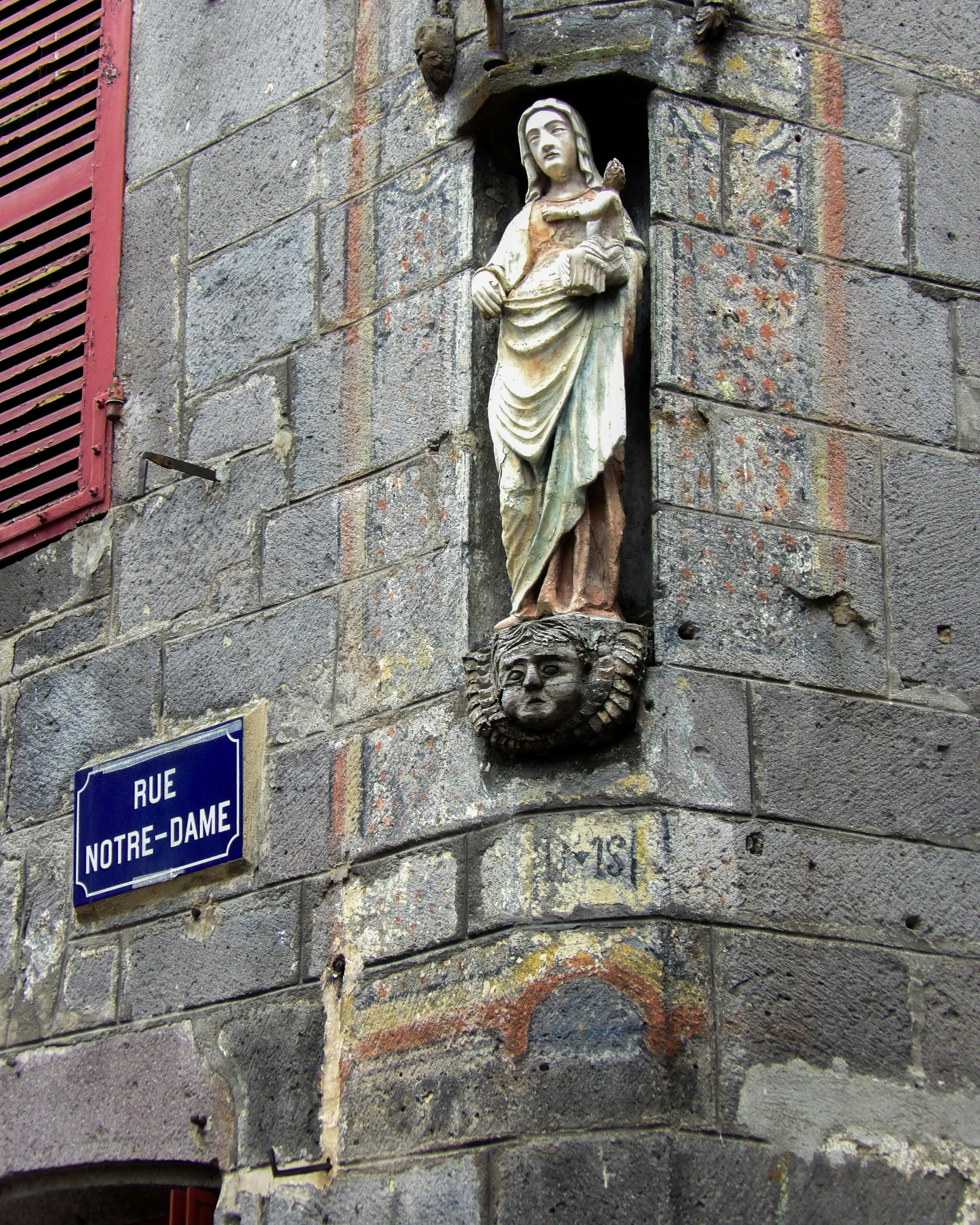 Stone sculpture on Rue Notre-Dame in a historic French city, showcasing religious art.