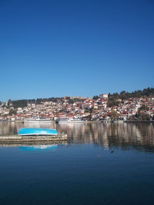 Free Beautiful view of Ohrid town reflecting on the tranquil Lake Ohrid under a clear blue sky. Stock Photo