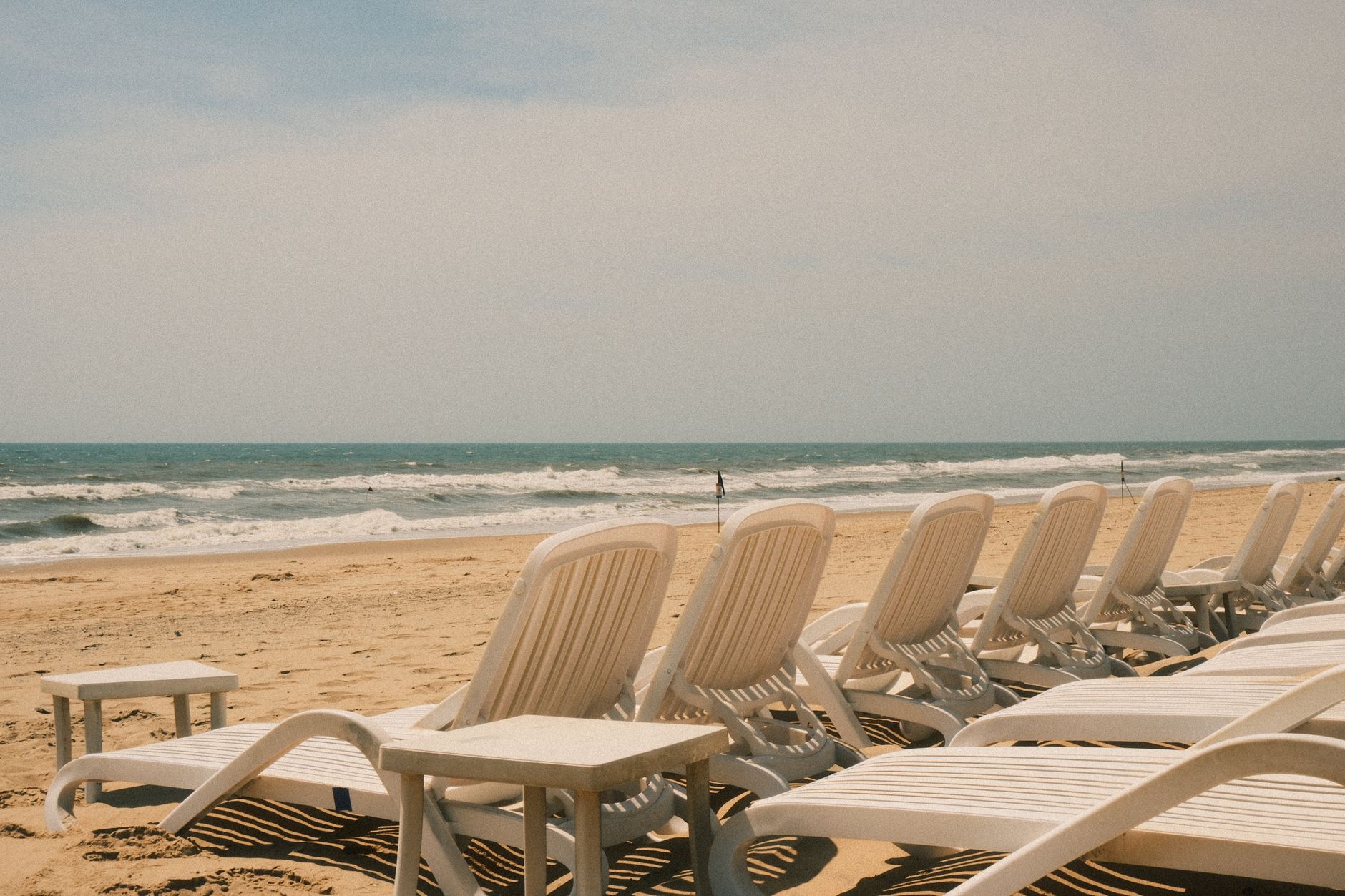 Peaceful beachfront scene with empty loungers in Phan Thiet, Vietnam.