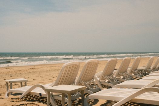 Peaceful beachfront scene with empty loungers in Phan Thiet, Vietnam.