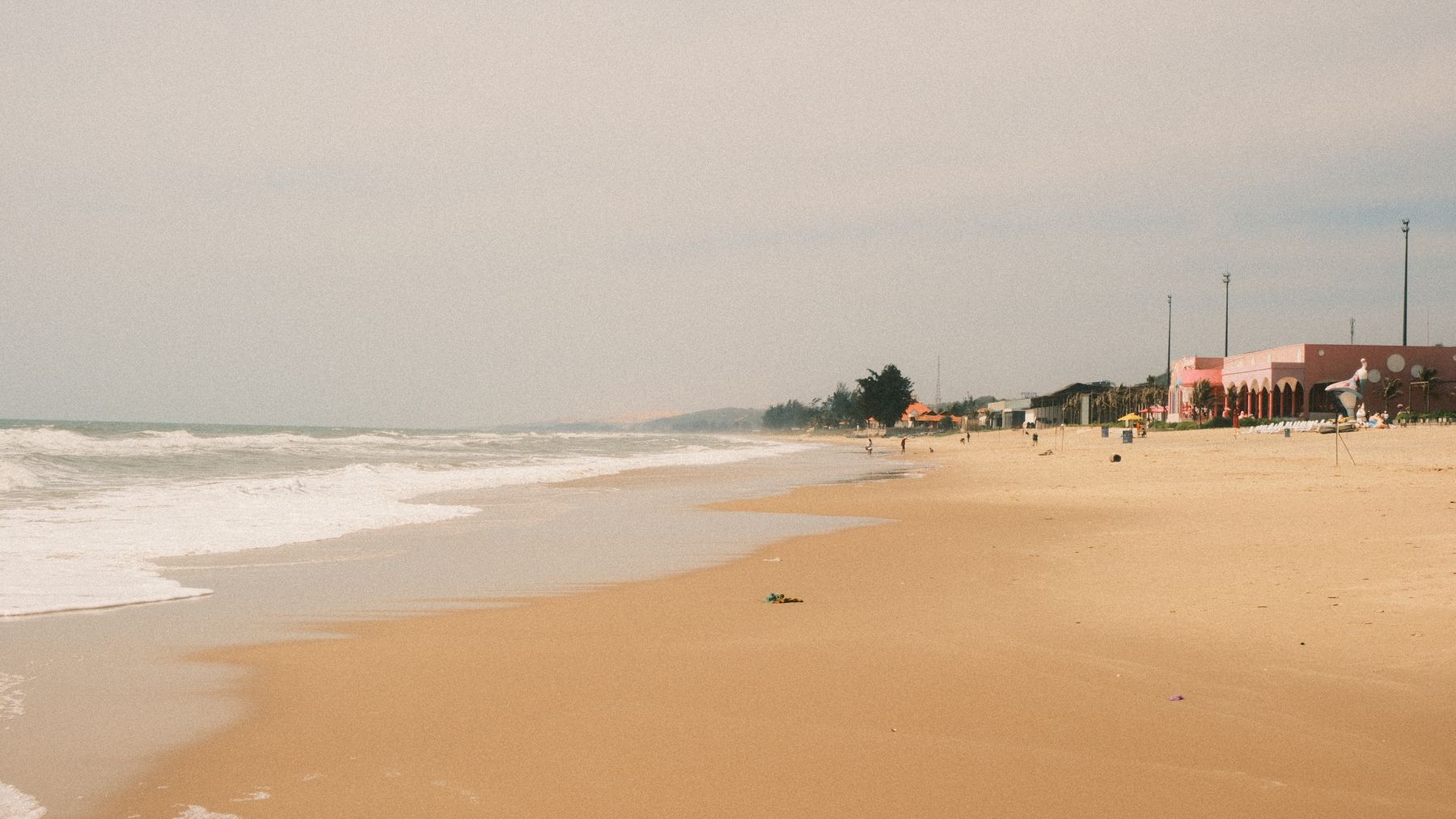 Tranquil beach scene in Phan Thiet, Vietnam with golden sand and gentle waves.