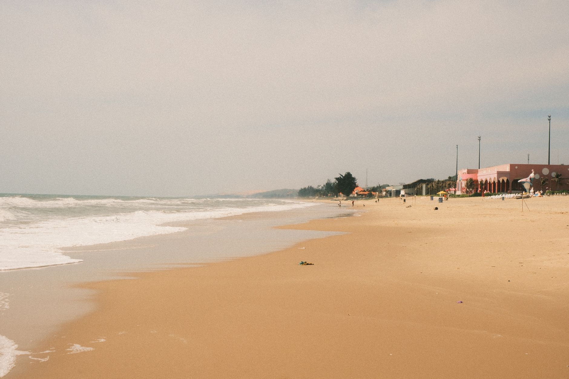 Tranquil beach scene in Phan Thiet, Vietnam with golden sand and gentle waves.