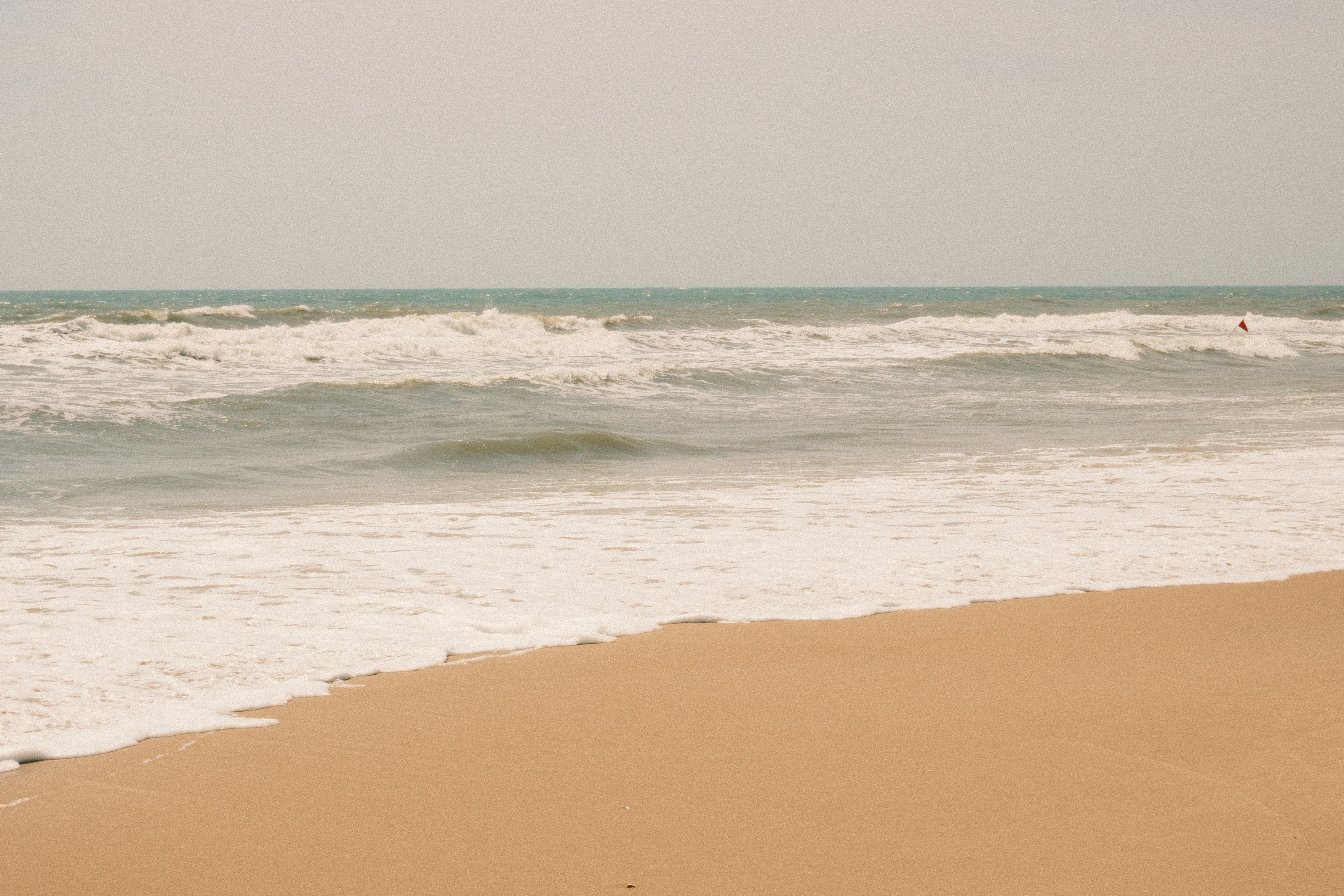 Peaceful beach with golden sands and gentle waves in Phan Thiet, Vietnam.