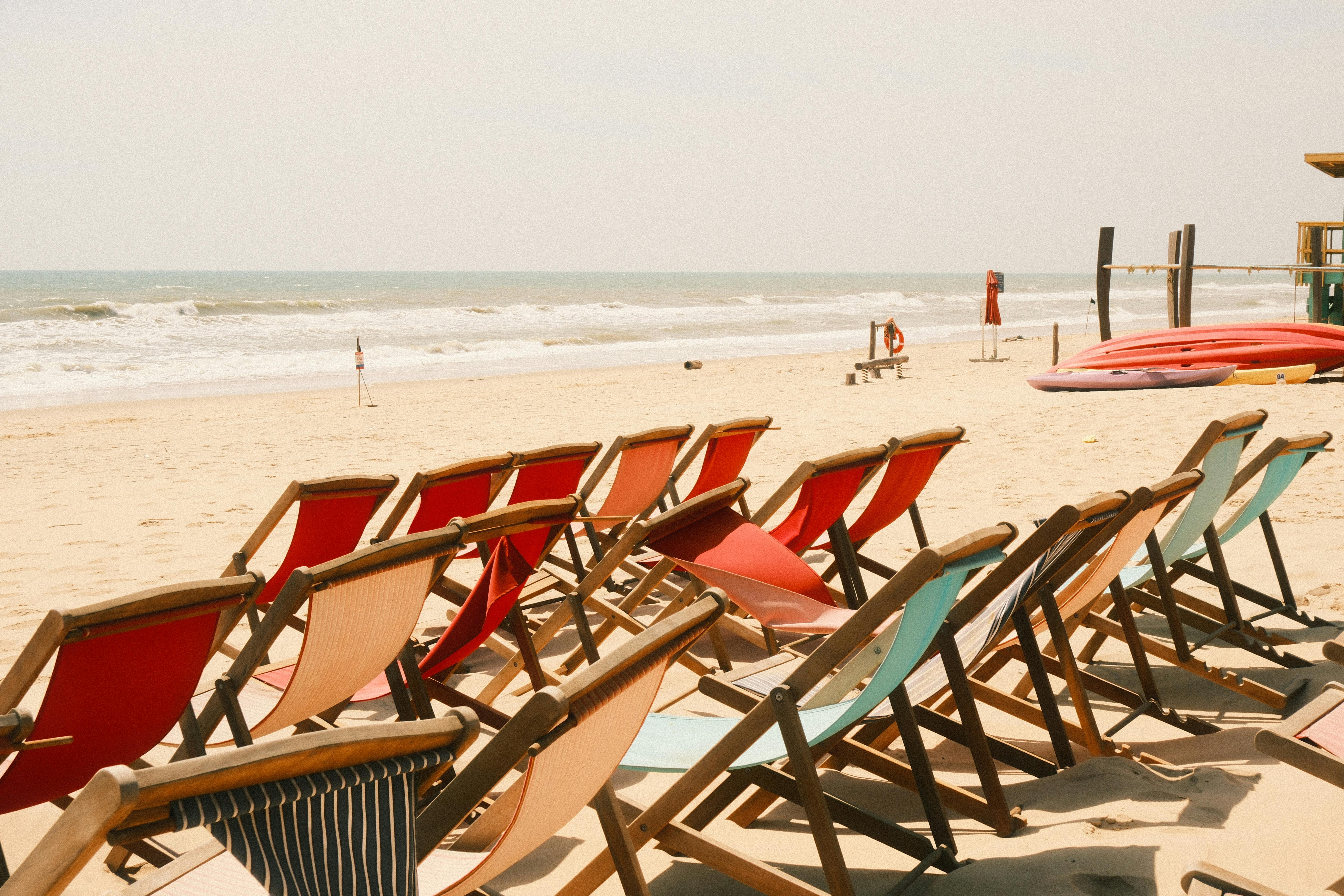 Rows of colorful beach chairs on a sandy shore in Phan Thiet, Vietnam, under bright sun.
