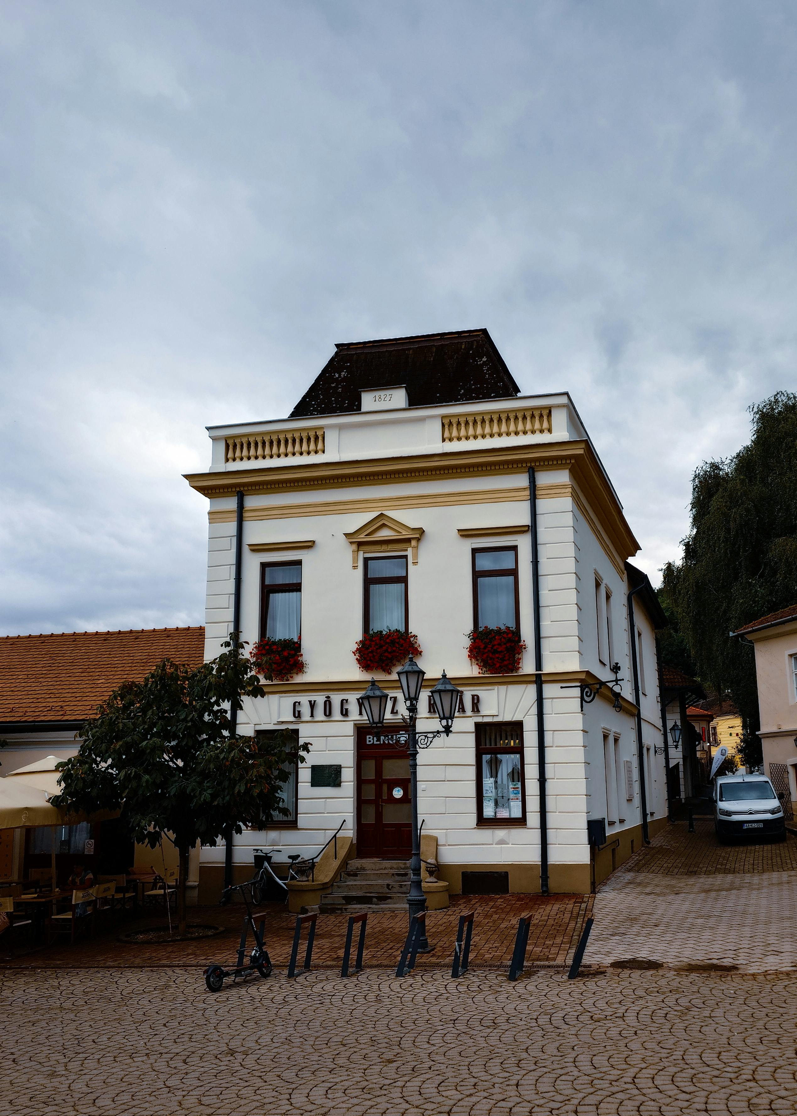 A picturesque historic building with classic architecture and flower decorations in a peaceful town setting.
