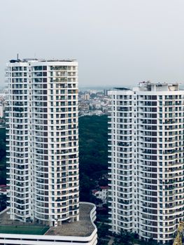 Two modern skyscrapers stand tall against an urban backdrop, showcasing contemporary architecture.