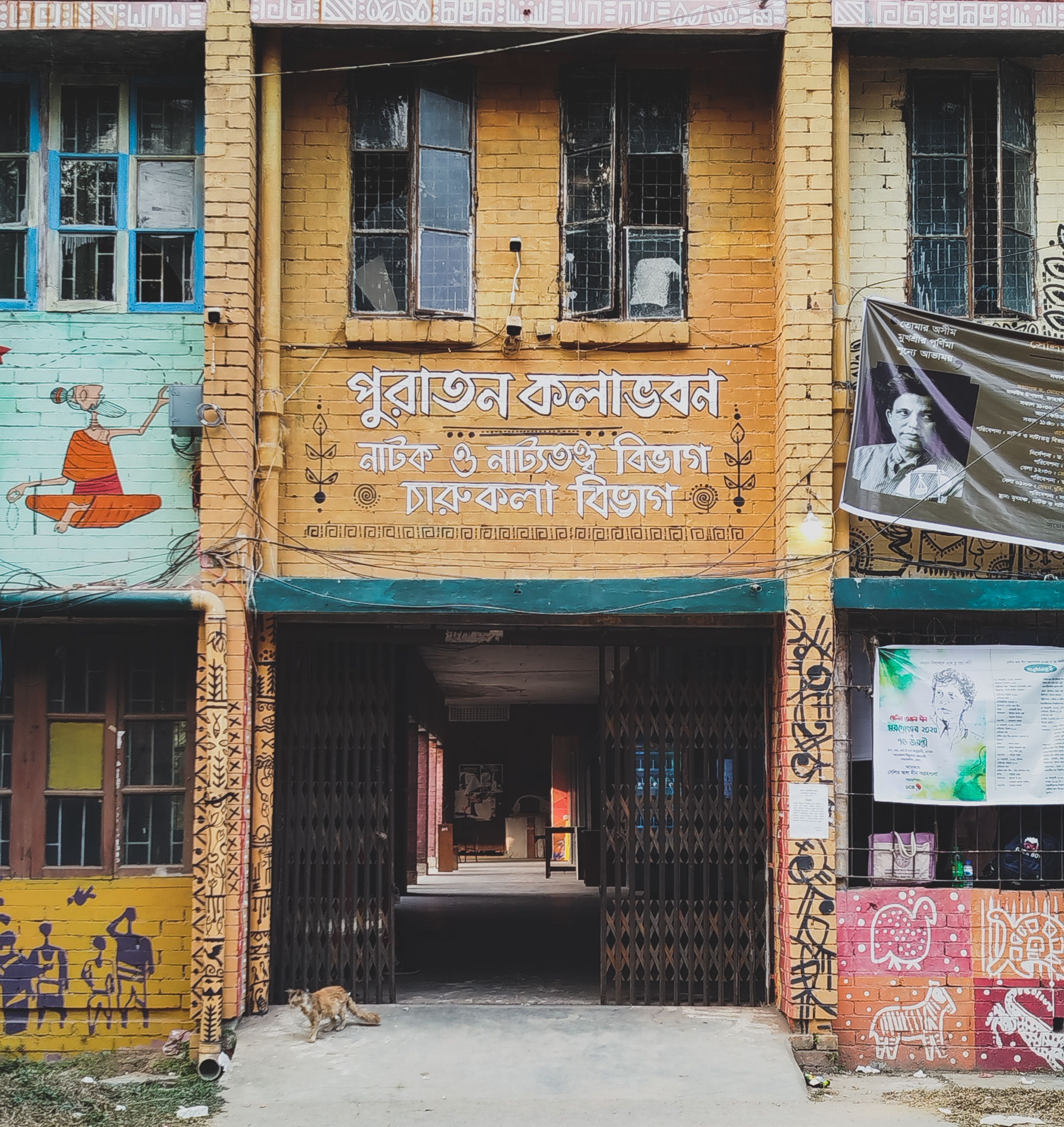 Vibrant facade of a traditional building adorned with intricate murals and regional script.