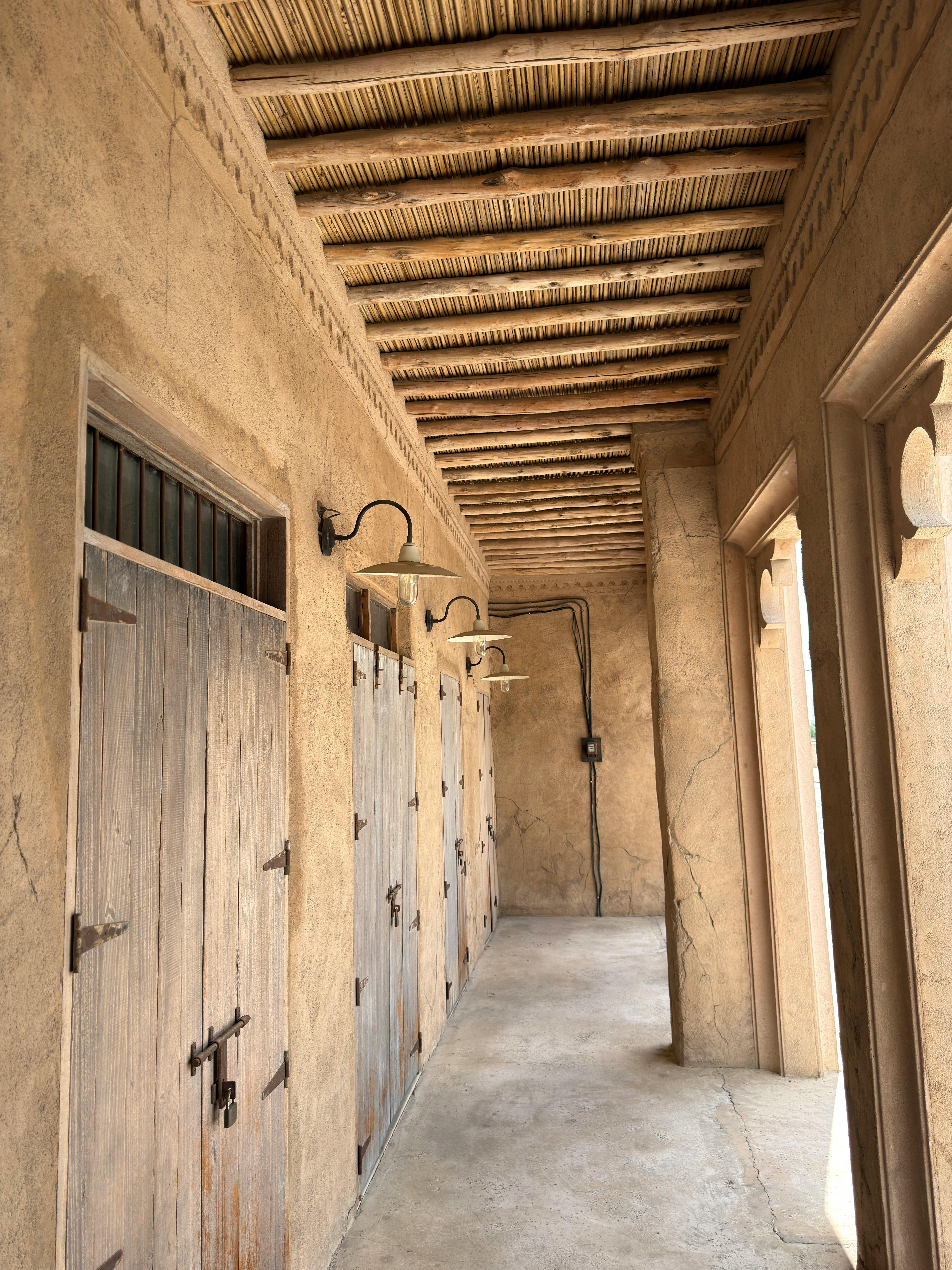 A corridor showcasing traditional Arabic architecture with wooden doors and ambient lighting.