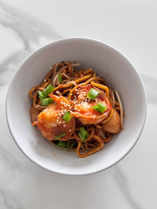 Free Top view of savory shrimp noodles garnished with green onions in a white bowl on marble surface. Stock Photo