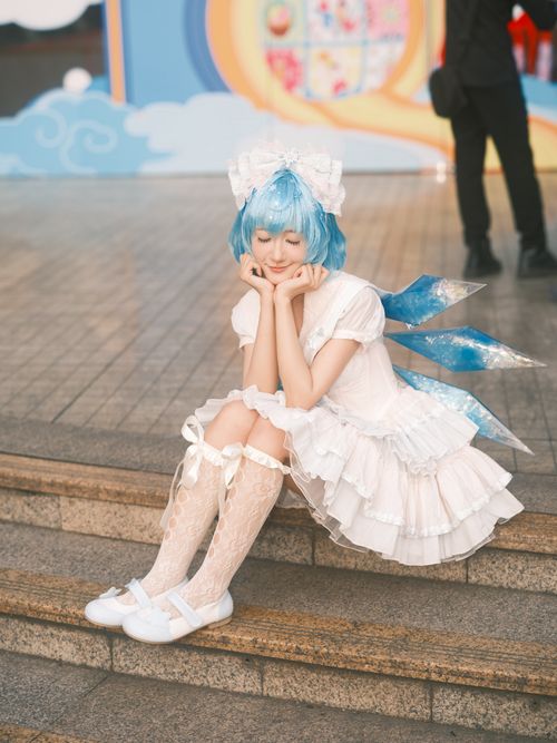 Free Young woman in anime cosplay with blue wig, sitting on steps, captures fantasy vibe in Vietnam. Stock Photo