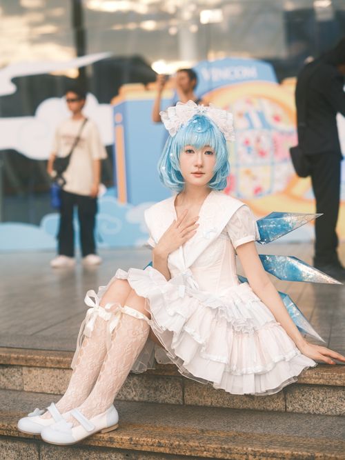 Free A person in blue hair and white fantasy cosplay outfit sits outdoors in Vietnam. Stock Photo