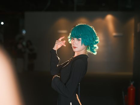 Artistic portrait of a person with teal hair in stylish attire, captured indoors in Vietnam.