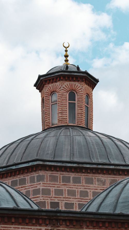 Free Close-up view of the dome and minaret of a historic mosque in Ankara, Türkiye, under a cloudy sky. Stock Photo