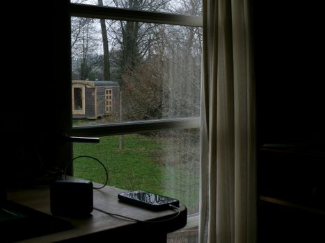 Glimpse of a rustic cabin outside a window with a serene nature view.