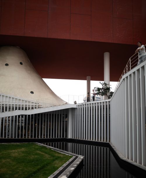 Free Unique architectural design featuring a striking red structure and geometric shapes. Stock Photo