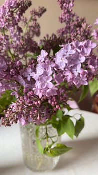 A vibrant close-up of blooming lilac flowers in a decorative glass vase.