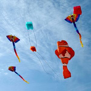 Colourful kites against a blue sky — Mone Kostner on Pexels