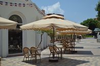 Charming outdoor cafe with tables, chairs, and beige umbrellas under a sunny sky.