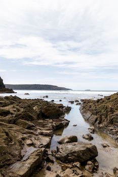Rocky coastline view in Wales with calm sea and scattered clouds, perfect for travel and nature themes.. pexels, rocky, coast