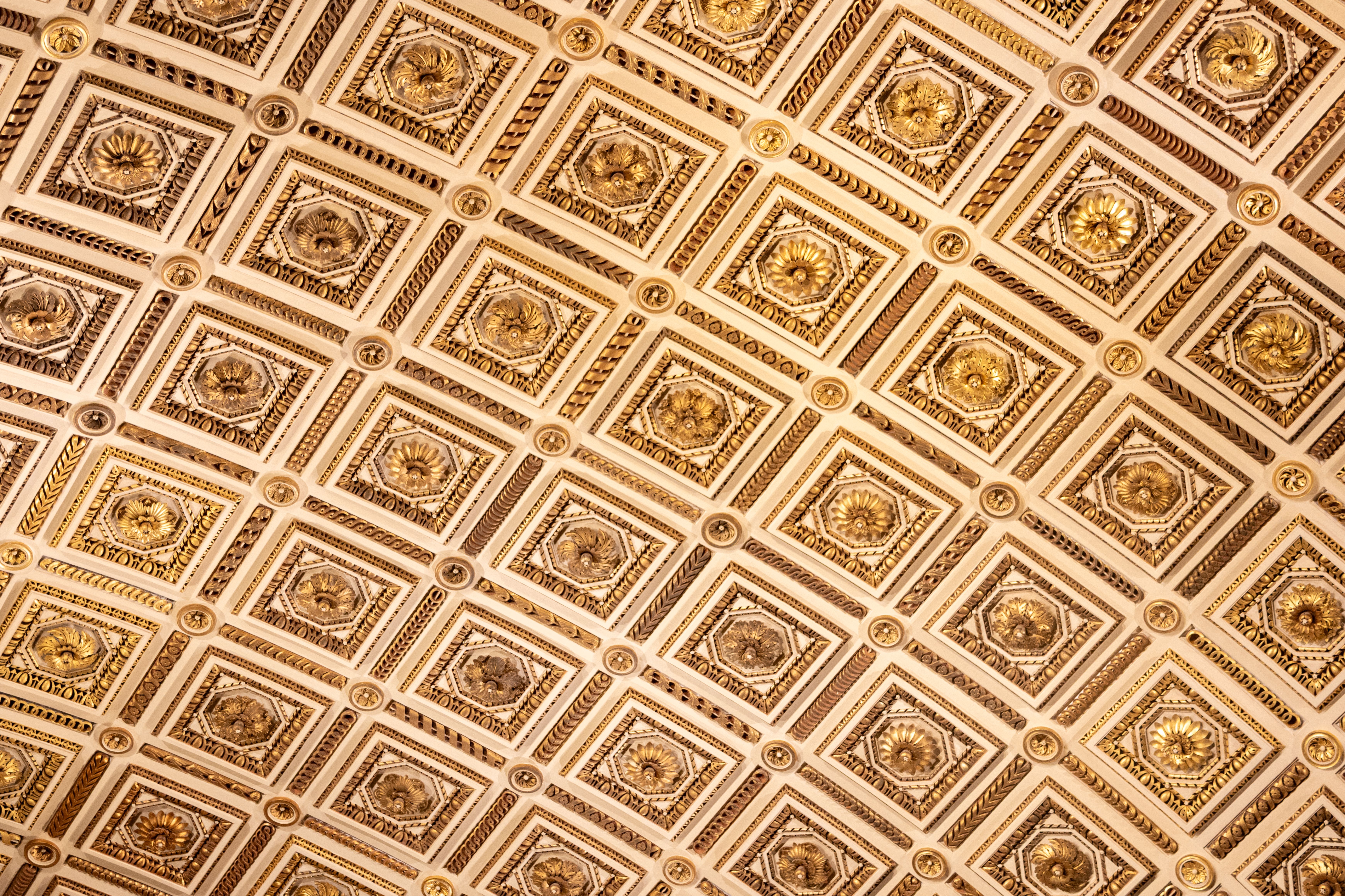 Vue détaillée du plafond richement décoré de la Galerie des Offices, à Florence, mettant en valeur des motifs artistiques complexes.