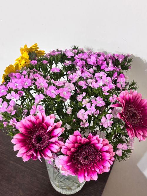 Free Elegant bouquet of vibrant pink and yellow flowers in a glass vase. Stock Photo