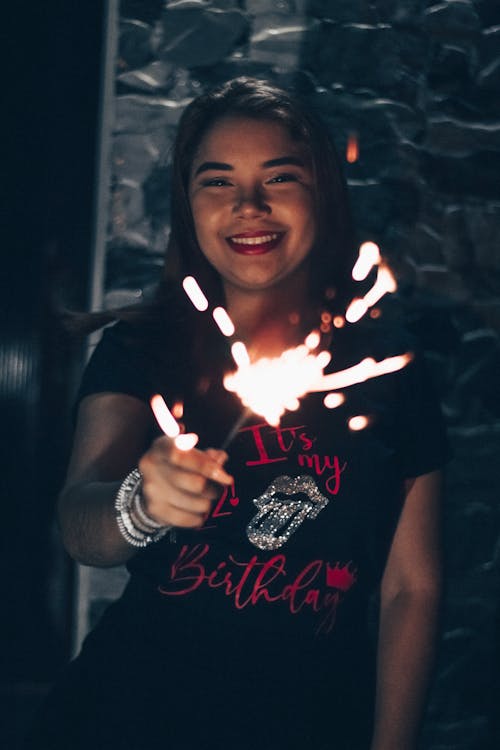 Young Woman Holding Lighted Sparkler