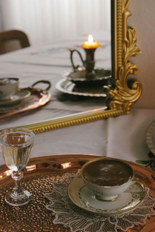 Free Charming coffee setting with an ornate gold mirror reflection, creating a vintage and warm ambiance. Stock Photo