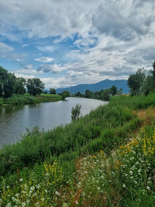 Free Lush greenery along Serchio River in Pisa, Tuscany, with mountains in the background. Stock Photo