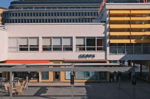 Free Exterior view of a modern commercial building with unique architectural design and colorful facade. Stock Photo