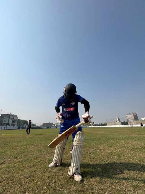 Free A cricket player in gear readying for a match on a sunny day at an outdoor stadium. Energetic sports ambience. Stock Photo