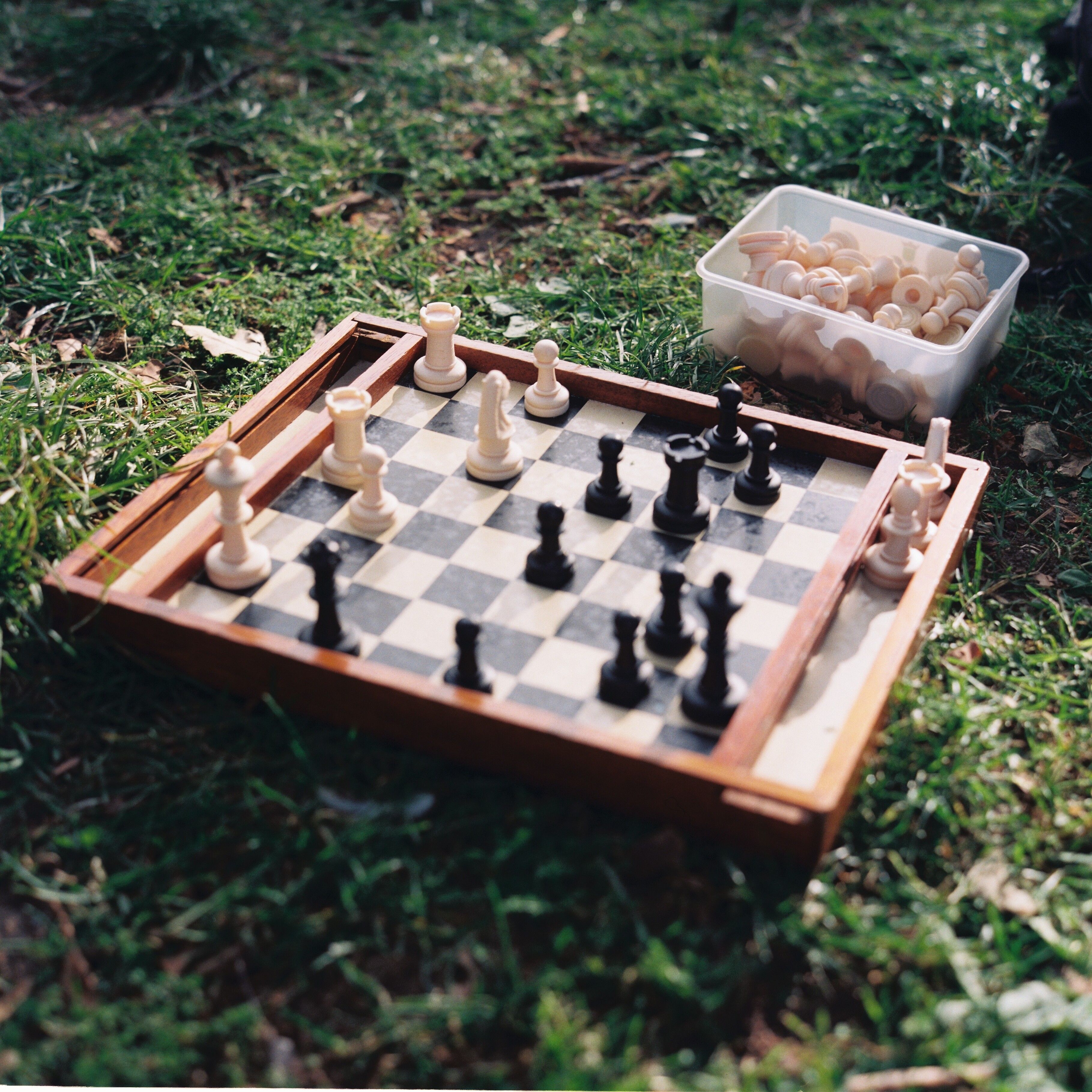 Strategic chess game set up on grass in Lisbon park, capturing a moment of outdoor relaxation.