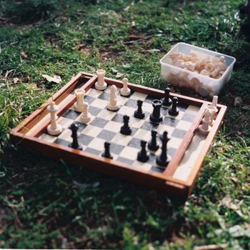 Strategic chess game set up on grass in Lisbon park, capturing a moment of outdoor relaxation.