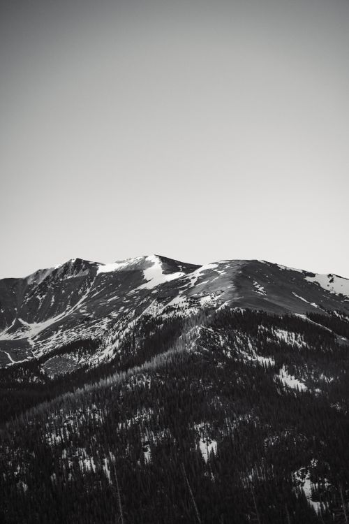 Free Breathtaking black and white photo of a snow-capped mountain under an expansive sky. Stock Photo