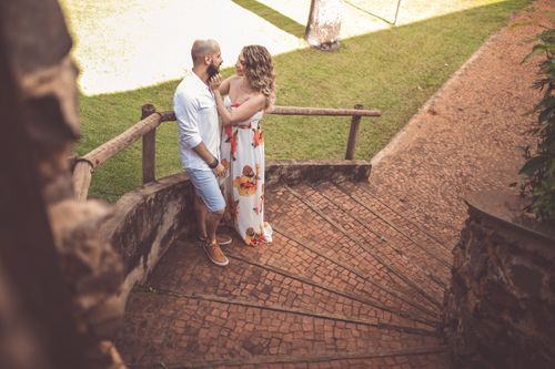 Free A couple shares a tender moment outdoors on stone steps, surrounded by greenery. Stock Photo