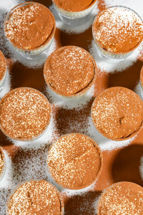 Free Multiple tiramisu desserts sprinkled with cocoa powder arranged in a grid pattern. Stock Photo