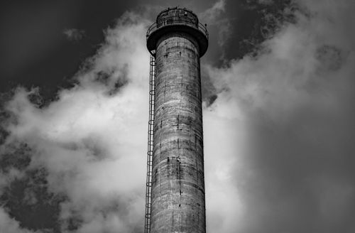 Free Black and white photo of an industrial chimney against a cloudy sky in Delhi, India. Stock Photo