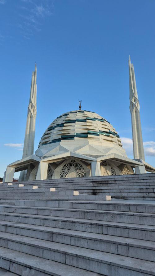 Free Modern Islamic architecture with a striking dome and minarets under a clear blue sky. Stock Photo