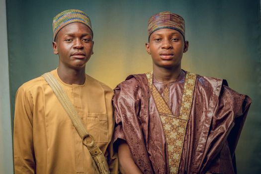 Portrait of two young men in traditional African attire, showcasing elegant cultural fashion.
