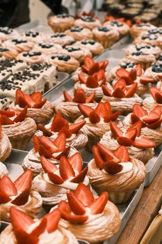 Mouthwatering assortment of pastries with fresh strawberries and cream on display.